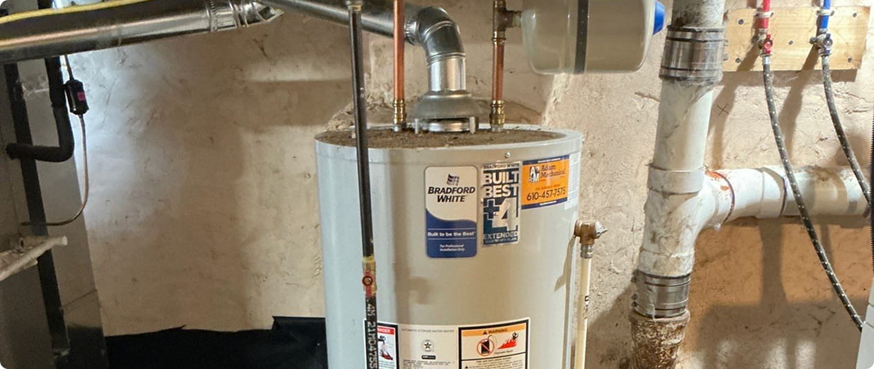 Water heater tank with pipes and connections installed in a basement setting.