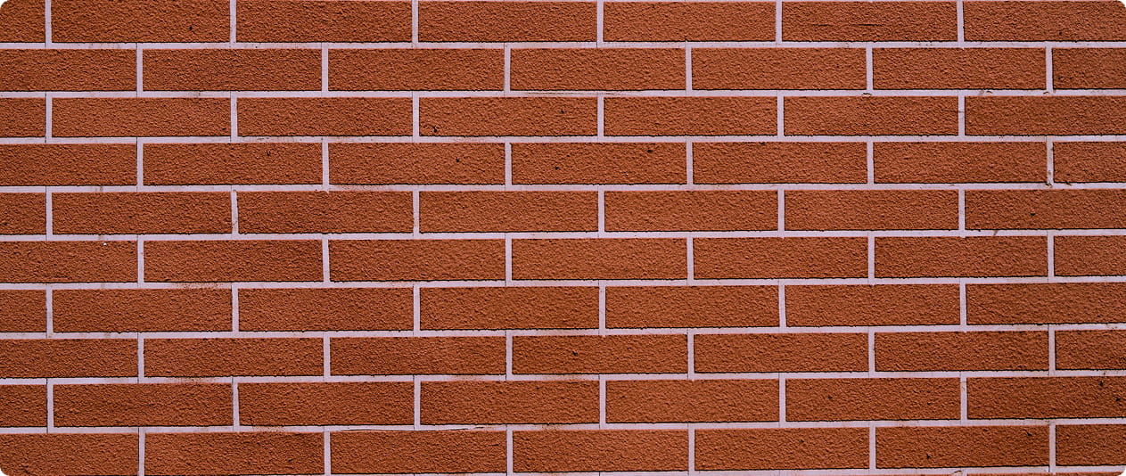 A close up view of a red brick wall with clean white mortar joints.