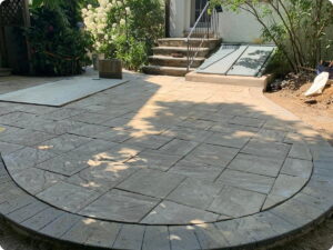 Stone patio with a circular border and stone steps leading up